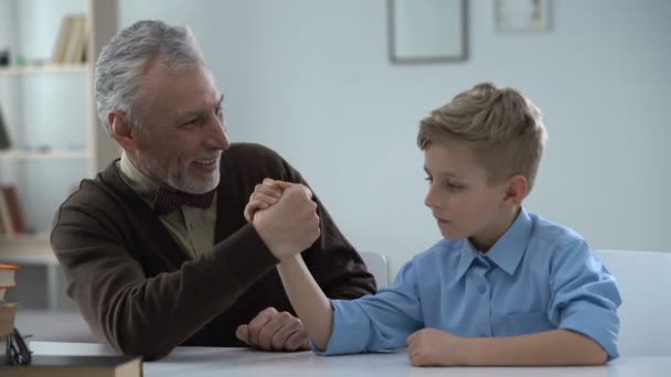 Boy Easily Defeating Grandfather Arm Wrestling Happy Victory Family Fun — Stock Video