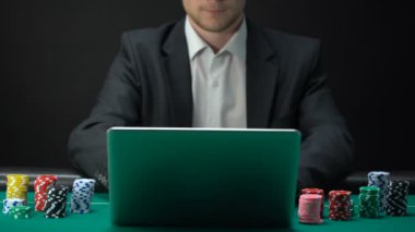 Dizüstü bilgisayarda çevrimiçi oyun, casino çip elinde tutan, bahis takım elbiseli adam
