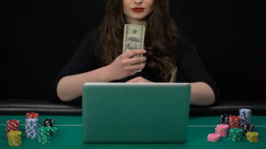 Dolar elinde tutan ve gülümseyen, ödül kazanan kadın online casino oyuncu