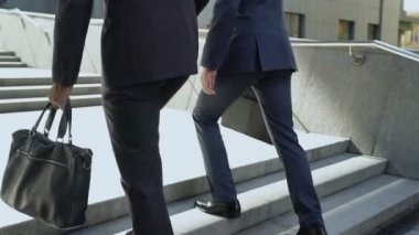 İki iş adamları, merdiven çıkma başarılı başlangıç, tartışırken ekip çalışması planları