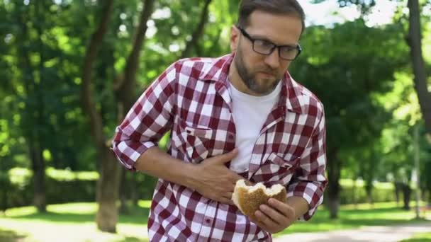 Hombre Con Hamburguesa Mano Sensación Náuseas Intoxicación Por Comida Chatarra — Vídeos de Stock