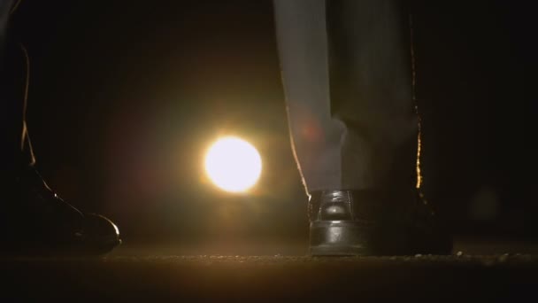 男が盗賊との夜の交渉のヘッドライトが付いている車に近づいて — ストック動画
