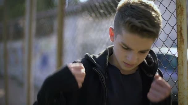 男孩倚在围栏 穿着连帽衫 孤儿在寄宿学校 — 图库视频影像