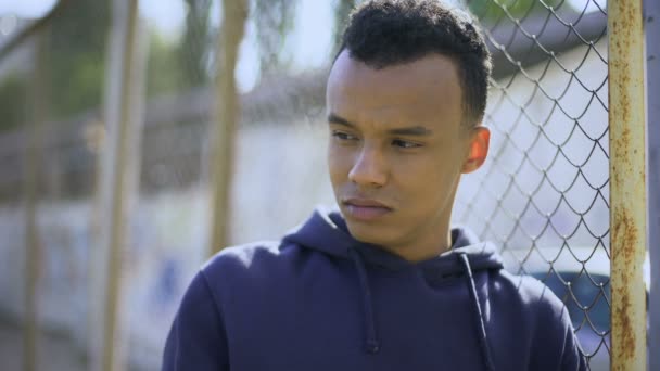フェンス 機能不全家族から若い難民に傾いているアフリカ系アメリカ人の少年 — ストック動画