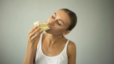İnce kız diyet ve aç, öz-disiplin eksikliği hevesle, pasta yemeye