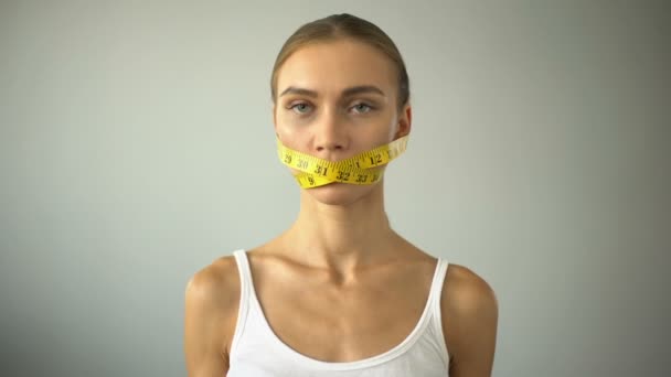 厌食女孩领带口与胶带线 与诱惑吃汉堡战斗 — 图库视频影像