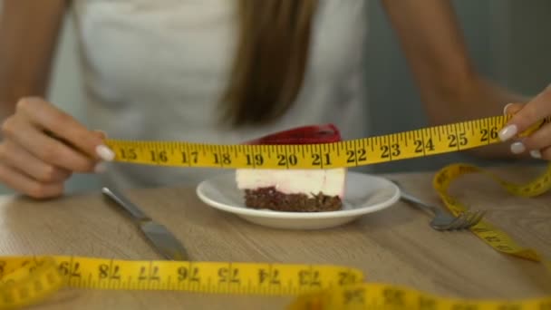 苗条女孩测量蛋糕与磁带线 计数卡路里的概念在饮食 — 图库视频影像