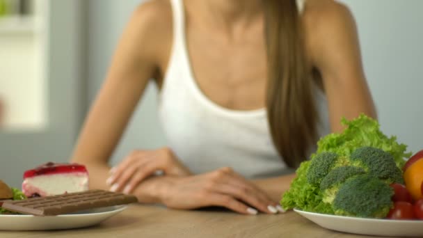 苗条女孩犹豫吃甜食或蔬菜 选择的概念 — 图库视频影像