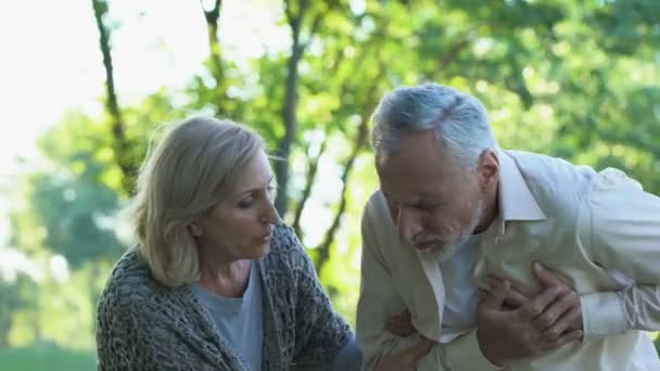 退休夫妇步行在公园 男性养老金领取人心脏病发作 — 图库视频影像