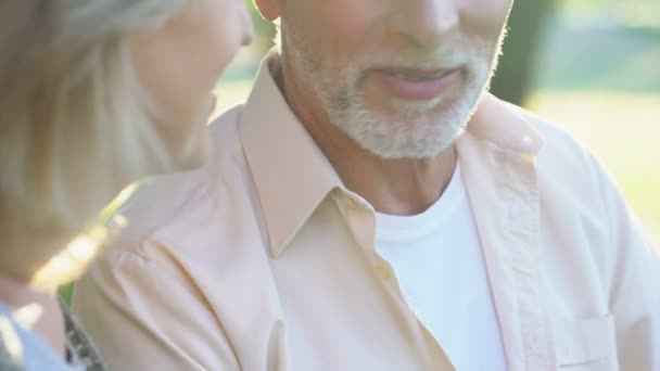 幸せな引退したカップル屋外でロマンチックなデートを楽しむ女性が男性の顔に触れる — ストック動画