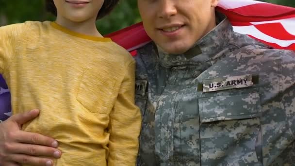 Patriotisk Soldat Som Klemmer Sin Lille Sønn Svøpt Amerikansk Flagg – stockvideo