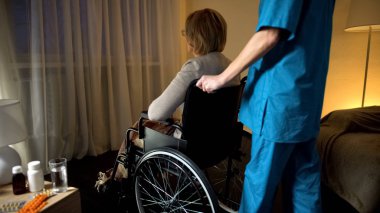 Hemşire getirerek eski tekerlekli sandalye kadın pencere Huzurevi yalnızlığa depresif