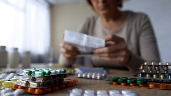 Farmaco Sdraiato Sul Tavolo Vecchia Malata Che Legge Prescrizione Dietro — Foto Stock