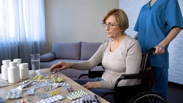 Enfermera Llevando Señora Mayor Silla Ruedas Mesa Para Tomar Medicamentos — Foto de Stock