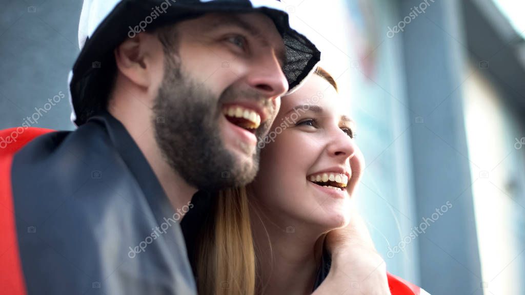 Cheerful football fans watching game, smiling and rejoicing new goal, victory