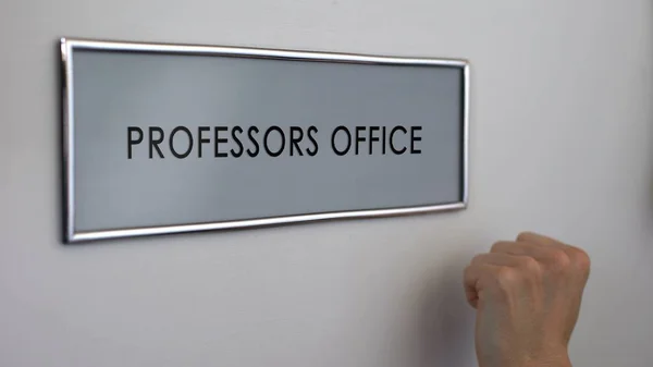 Professors office door, hand knocking closeup, university lecturers workplace