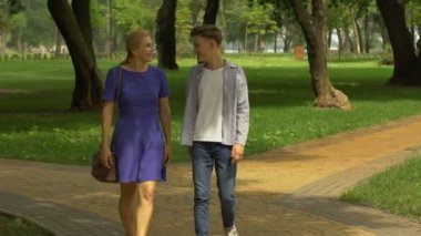 Anne ile oğlu parkta yürürken, gelecekteki eğitim ve kariyer hakkında iletişim