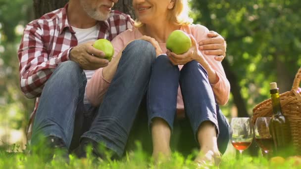 在公园里拿着苹果的老年夫妇 天然食物和医疗推荐 — 图库视频影像