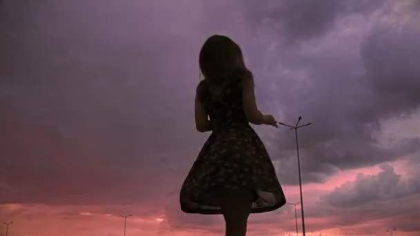 微笑的快乐女士在傍晚的天空下穿着夏装转身 — 图库视频影像