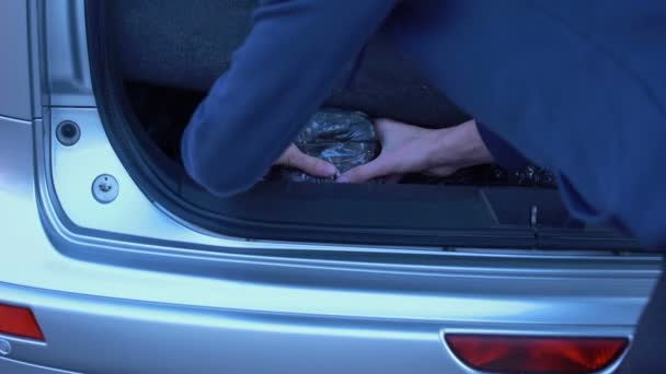 Άνθρωπος Κρύβει Απαγορευμένη Πακέτα Στο Πορτ Μπαγκάζ Αυτοκινήτου Ναρκωτικά Λαθρεμπόριο — Αρχείο Βίντεο