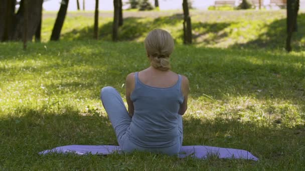 Γυναίκα Κάθεται Στο Χαλί Κάνει Asana Γιόγκα Διαλογισμό Στο Πάρκο — Αρχείο Βίντεο