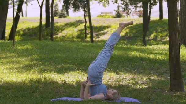 Mujer Mayor Forma Haciendo Yoga Parque Estera Hombro Pie Asana — Vídeo de stock