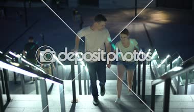 Kaygısız çift üst katta ışıklı gece city izlemek için dolgu için yürüyüş