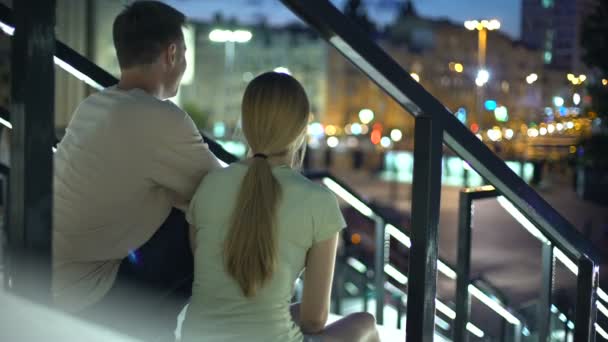 Para Siedząc Schodach Obejmując Oglądając Oświetlone Wieczorem Miasta Miłość — Wideo stockowe