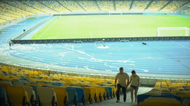 スポーツ イベントで出会い 試合後スタジアムを残してのフットボールのファンのカップル — ストック動画