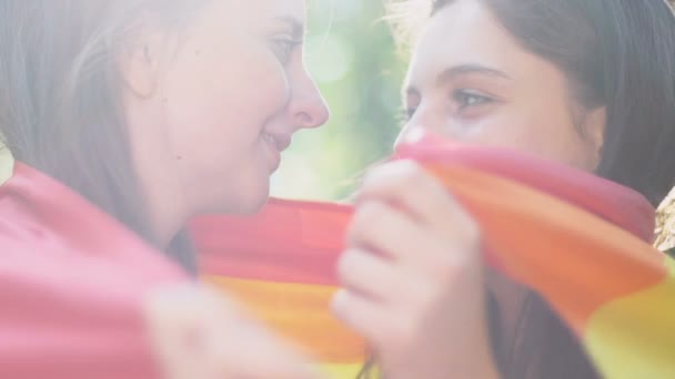 Two Cheerful Lesbians Wrapped Rainbow Flag Hugging Kissing Outdoors — Stock Video