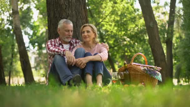 Ευτυχισμένος Ηλικιωμένους Ζευγάρι Κάθεται Στο Γρασίδι Και Απολαμβάνοντας Ρομαντική Ημερομηνία — Αρχείο Βίντεο