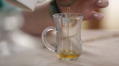 Kadın dikkatle kehribar çay cam, tazelik ve kalite içki dökme