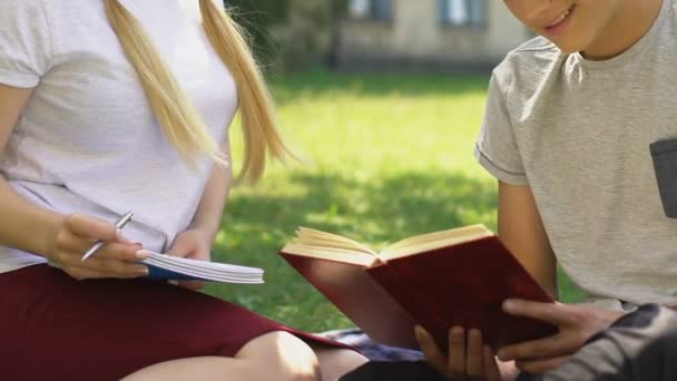 聪明的十几岁的男孩帮助女孩在户外做作业 准备考试 — 图库视频影像