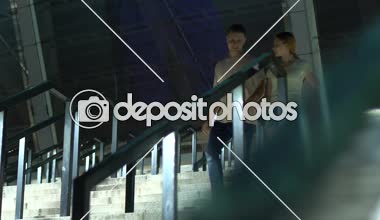 Mutlu genç insanlar merdivenlerden inip, iyimser ve neşeli gülümsüyor yüzler üzerinde çalışan