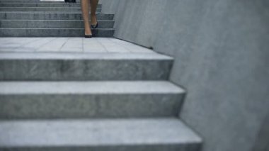 Kadın tereddütle yüksek topuklu ayakkabılar, iş çıkışı yorgun varis yürüyüş