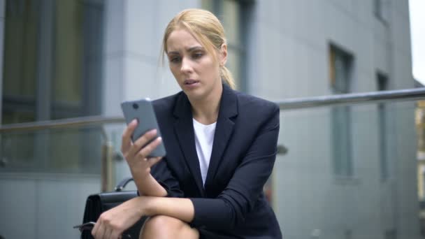 女商人对智能手机中的信息 工作中的烦恼 抑郁感到不安 — 图库视频影像