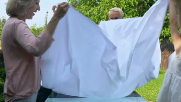 Внуки Помогают Бабушке Дедушке Накрывать Стол Белой Тканью Посещение Праздников — стоковое видео