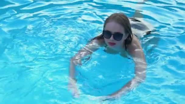 澄んだ青い水で泳ぐファッション サングラスで陽気な女性は 夏のリラックス — ストック動画
