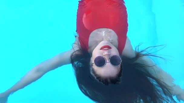 女士穿着红色泳衣躺在水面上 享受新鲜的凉水 — 图库视频影像