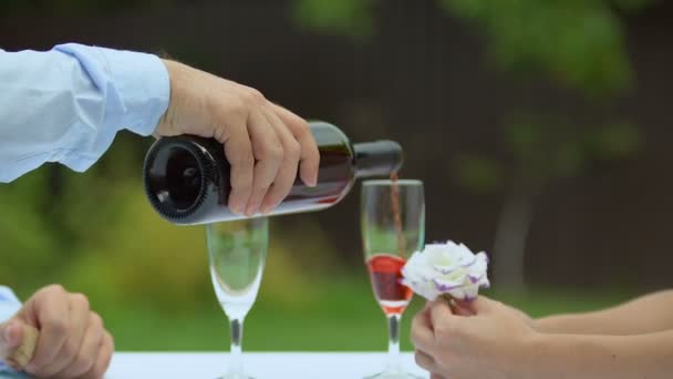 Мужчина Наливает Красное Вино Бокалы Женщина Держит Цветок Романтическое Свидание — стоковое видео