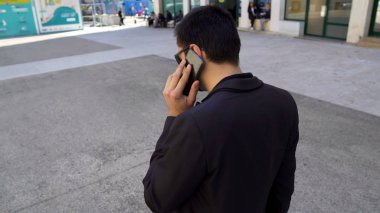 Telefonla konuşma ve şehir sokak, aktif yaşam yürüyüş koyu takım elbiseli meşgul adam