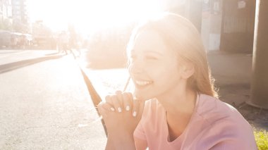 Gülümseyerek, Güneş ışınları, yürüyüşten sonra dinlenme kaldırımda oturan güzel kız