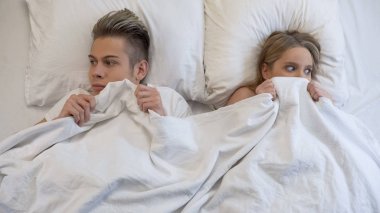 Young man and woman looking embarrassed before first intimacy in bed, insecurity clipart