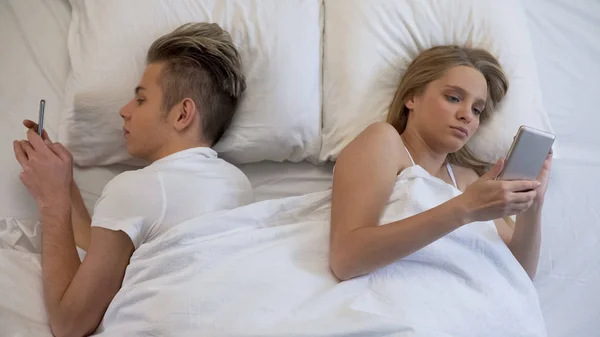 夫妇躺在床上的智能手机 社交网络 — 图库照片