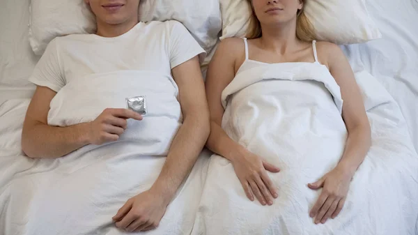 Jovem Segurando Preservativo Sugerindo Intimidade Com Namorada Atitude Responsável — Fotografia de Stock
