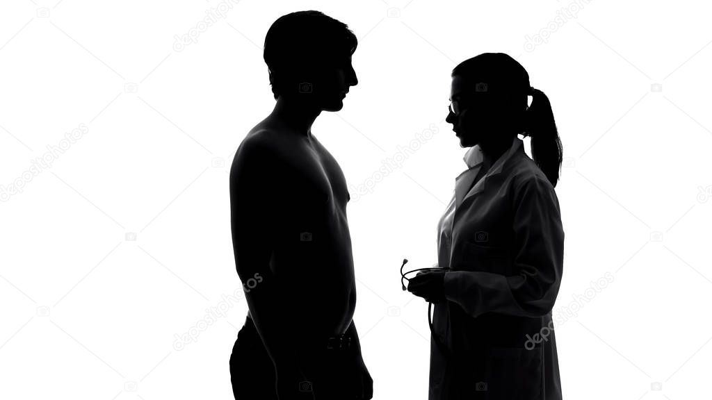 Male patient on medical examination, female doctor with stethoscope talks to man