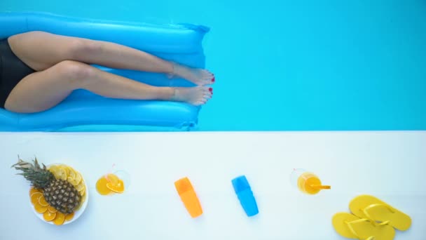 スイミング プールで青い空気マットレスの上ビキニでスリムな若い女性のトップ ビュー — ストック動画