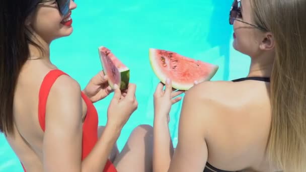 セクシーな女性の笑いとスイミング プールの近くにスイカを食べて夏休み — ストック動画