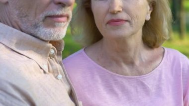 Mutlu gülümseyen yaşlı kadın yaşlı adam, ağır çekim omzuna başını koyarak