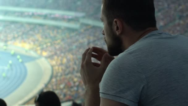 Αρσενικό Υποστηρικτής Βλέποντας Αθλητισμού Παιχνίδι Στο Γήπεδο Συμπυκνωμένο Και Ταραγμένος — Αρχείο Βίντεο